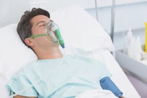 Incapacitated man asleep in a hospital bed.